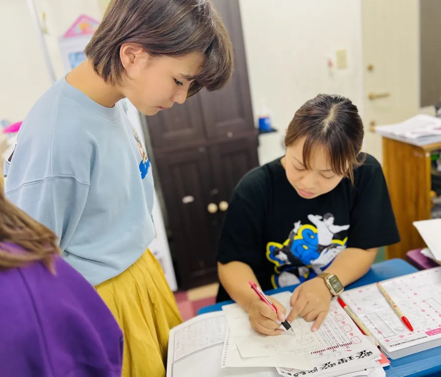 生徒のそばで答案に書き込みながら確認する先生