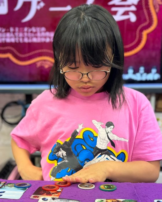 ボードゲームの盤面を見ながら次の一手を考える女子児童