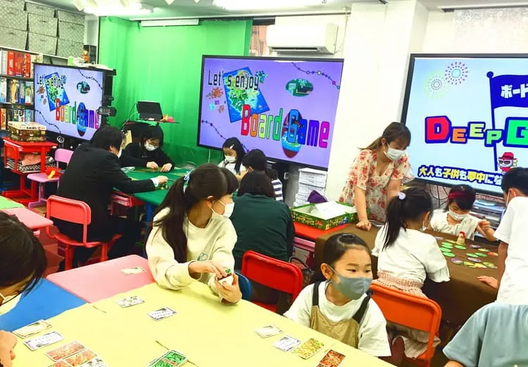 DGの教室で大人も子どもも一緒にボードゲームを楽しむ様子